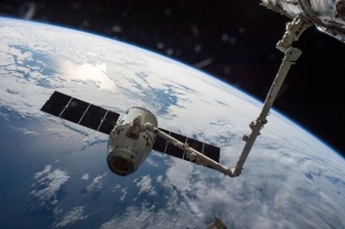 Dragon-forsyningsfartøy fanget inn av romstasjonens robotarm. NASA Dragon-forsyningsfartøy fanget inn av romstasjonens robotarm. NASA