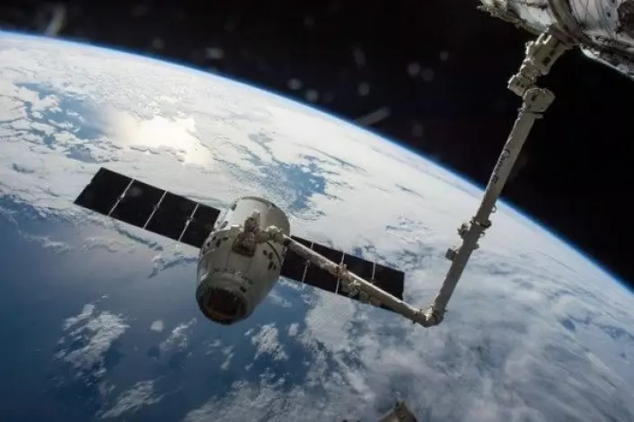 Dragon-forsyningsfartøy fanget inn av romstasjonens robotarm. NASA