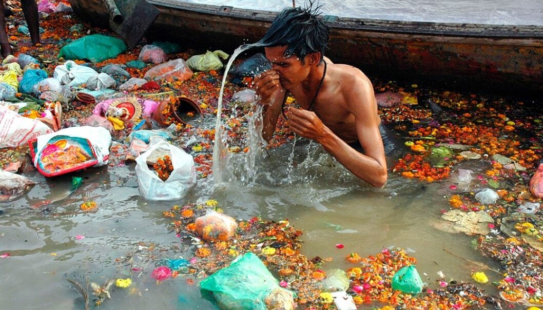 En hindu gjør et religiøst ritual i Yamuna, en sideelv til Ganges i India. Rundt ham flyter det plastsøppel.  (Foto: Jitendra Prakash/Reuters/NTB scanpix)