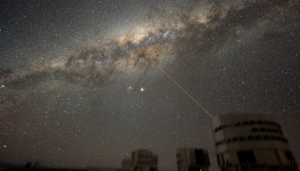 Melkeveien sett fra jorden. Laserstrålen peker rett mot galaksesenteret, og den kommer fra observatoriet, som ligger i Sør-Amerika.  (Bilde: ESO)