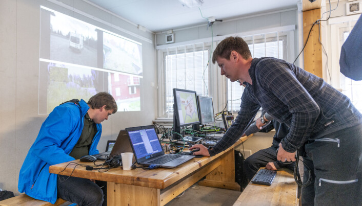 Inne i brakka på Rena. Forskerne ser UGV-enes innbyrdes posisjoner på skjermen, de har videooverføring fra enhetenes kameraer og styrer det hele fra et par kontrollenheter. (Foto: Christian Tandberg / FFI) Inne i brakka på Rena. Forskerne ser UGV-enes innbyrdes posisjoner på skjermen, de har videooverføring fra enhetenes kameraer og styrer det hele fra et par kontrollenheter. (Foto: Christian Tandberg / FFI)
