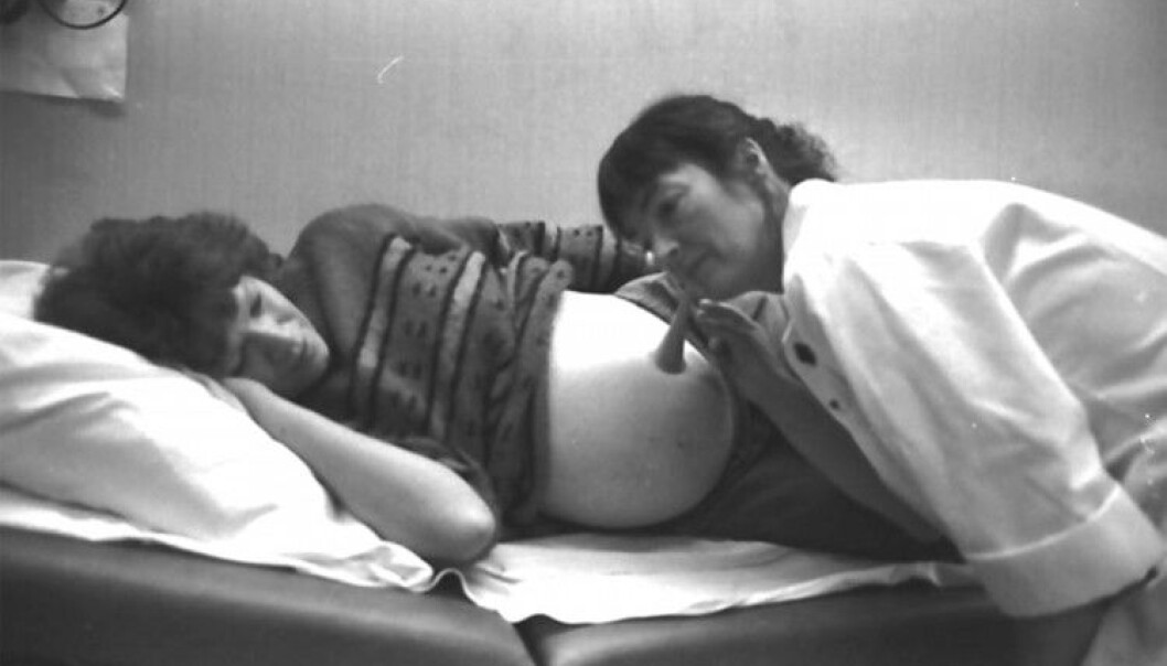 En jordmor i Tynset bruker hørerør for å lytte til fosteret tilstand og plassering i magen. Bildet er tatt i 1990. (Foto: Per Magne Grue/Musea i Nord-Østerdalen) En jordmor i Tynset bruker hørerør for å lytte til fosteret tilstand og plassering i magen. Bildet er tatt i 1990. (Foto: Per Magne Grue/Musea i Nord-Østerdalen)