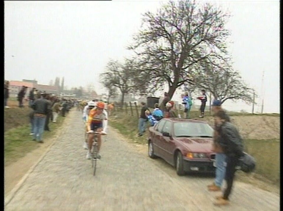 En uidentifisert Rabobank-rytter leder an forbi pæretre med litt blader til høyre. Rittet i 1996 ble vunnet av Michele Bartoli.