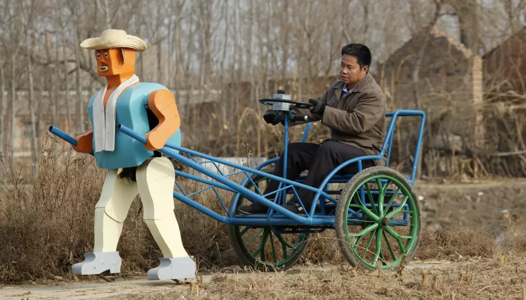 Blir man født kreativ? Her viser den kinesiske oppfinneren og bonden Wu Yulu fram roboten sin. Han har bygget roboter siden åttitallet og alle sammen er laget av ting han har funnet på søppelhauger. (Foto: Reinhard Krause, reuters, NTB scanpix)