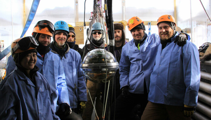   part of the team behind the IceCube project in front of one of the sensors coming down the ice. There are more than 5000 sensors there. (Image: AFP PHOTO / HO / NSF / F. DECAMPS / NTB Scanpix) 