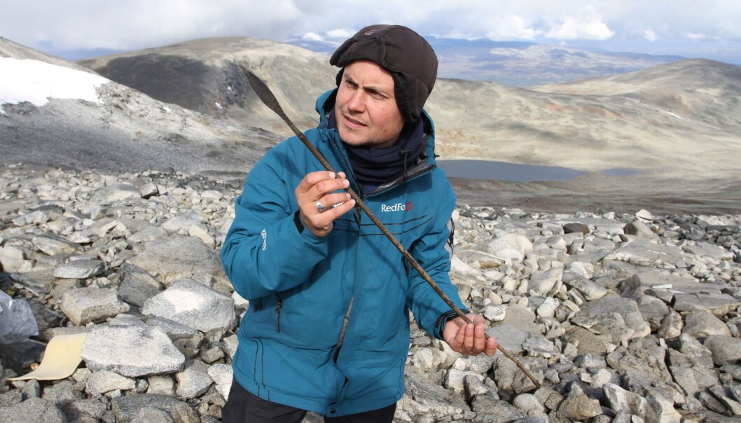 En arkeolog holder en ca. 1400 år gammel pil, som gikk tapt i forbindelse med reinsjakt i høyfjellet i Oppland under the Late Antique Little Ice Age. (Foto: Julian Martinsen, secretsoftheice.com/Oppland fylkeskommune) En arkeolog holder en ca. 1400 år gammel pil, som gikk tapt i forbindelse med reinsjakt i høyfjellet i Oppland under the Late Antique Little Ice Age. (Foto: Julian Martinsen, secretsoftheice.com/Oppland fylkeskommune)