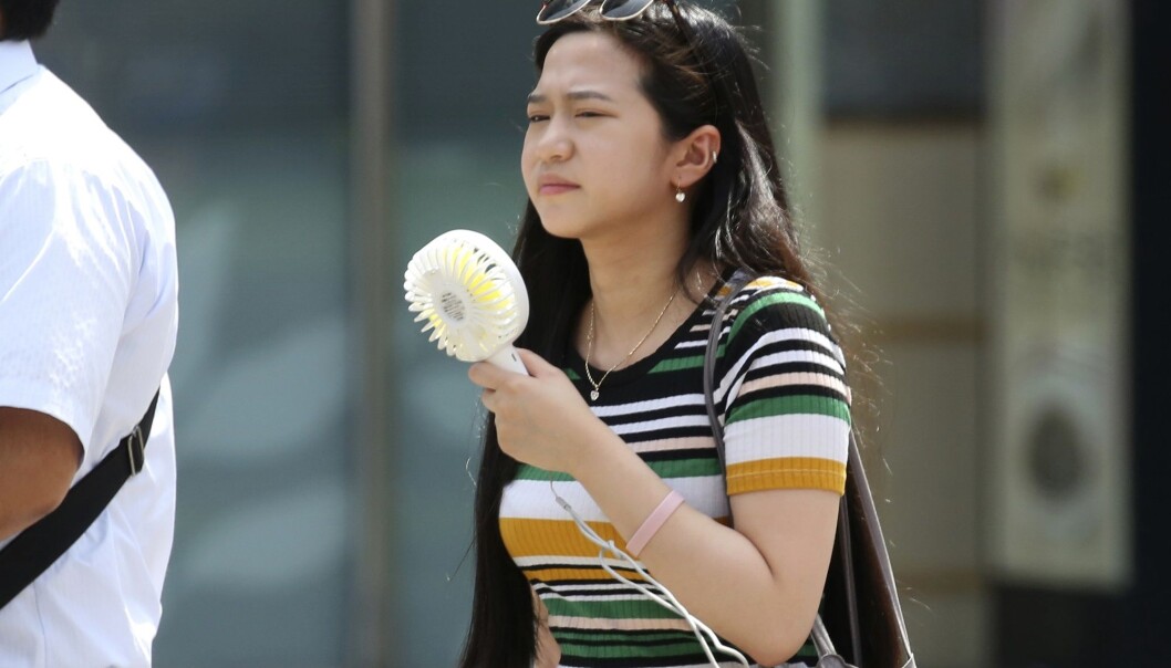 En kvinne i Tokyo forsøker å kjøle seg ned med en håndholdt vifte under hetebølgen. Mandag ble det satt ny varmerekord i Japan med 41,1 grader. (Foto: Koji Sasahara, AP Photo, NTB scanpix) En kvinne i Tokyo forsøker å kjøle seg ned med en håndholdt vifte under hetebølgen. Mandag ble det satt ny varmerekord i Japan med 41,1 grader. (Foto: Koji Sasahara, AP Photo, NTB scanpix)