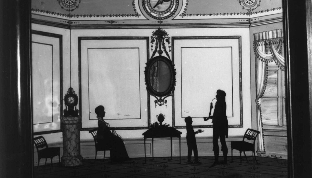 Familiebilde: Noen silhuetter ble også lagt oppå tegnede bakgrunner. Slik fikk man vist også familiens stue og hjem (Eier: Norsk folkemuseum) Familiebilde: Noen silhuetter ble også lagt oppå tegnede bakgrunner. Slik fikk man vist også familiens stue og hjem (Eier: Norsk folkemuseum)