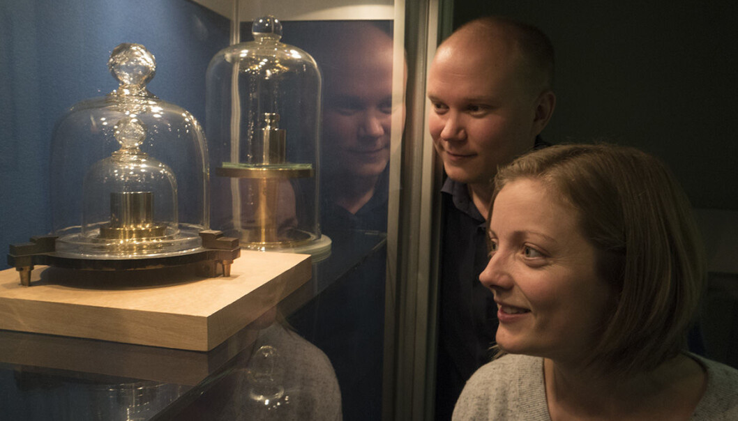 Den norske kopien av standard kilogramloddet er innelåst i en monter hos Justervesenet på Kjeller utenfor Oslo. Pekka Neuvonen er norsk deltaker i det internasjonale arbeidet for å løfte kiloen ut fra forgjengelig metall til evige naturkostanter. Marit Ulset Nordsveen har bidratt med forskning rundt målemetoder. (Foto: Arnfinn Christensen) Den norske kopien av standard kilogramloddet er innelåst i en monter hos Justervesenet på Kjeller utenfor Oslo. Pekka Neuvonen er norsk deltaker i det internasjonale arbeidet for å løfte kiloen ut fra forgjengelig metall til evige naturkostanter. Marit Ulset Nordsveen har bidratt med forskning rundt målemetoder. (Foto: Arnfinn Christensen)