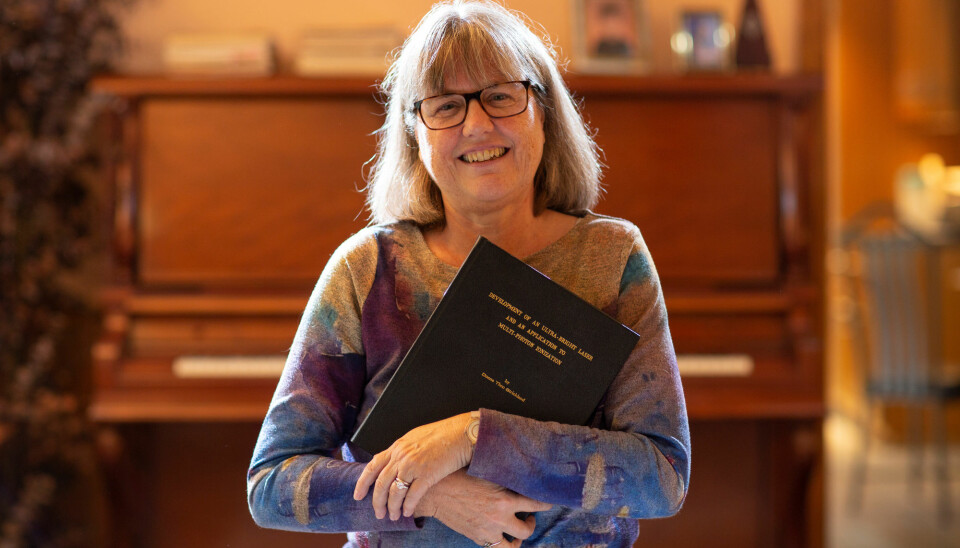 Donna Strickland viser frem doktorgradsavhandlingen som nå har gitt henne en nobelpris i fysikk. Hun er en av tre kvinner i verdenshistorien som har blitt tildelt prisen. (Foto: Peter Power / Reuters / NTB scanpix)