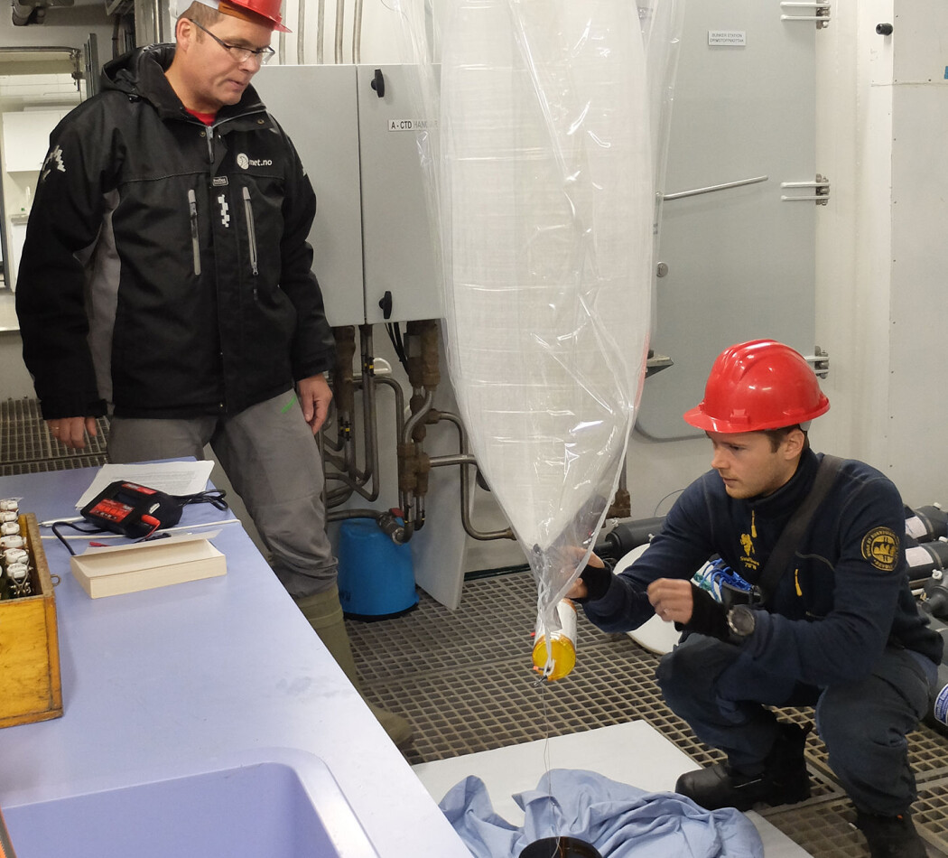 Lars Hole (til venstre) og Jean Rabault har fylt ballongen og sjekker at instrumentet og solcellepanelet fungerer som det skal. (Foto: Inger Lise Næss/UNIS) Lars Hole (til venstre) og Jean Rabault har fylt ballongen og sjekker at instrumentet og solcellepanelet fungerer som det skal. (Foto: Inger Lise Næss/UNIS)