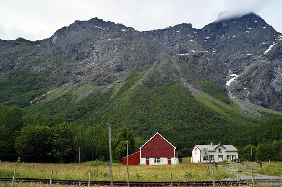 Mannen troner høyt over Romsdalen, hele 1294 meter over havet. Lengst oppe, hvor skredene utløses, er det stupbratt. Under ligger skredmassene som nå er datert. I forgrunnen ligger skinnegangen til Raumabanen. (Foto: NGU)