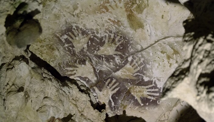 Dette bildet viser håndstensiler fra forskjellige tidsperioder. De mørkere stensilene er sannsynligvis 20 000 år yngre enn de lysere, mer svake stensilene. (Bilde: Kinez Riza) Dette bildet viser håndstensiler fra forskjellige tidsperioder. De mørkere stensilene er sannsynligvis 20 000 år yngre enn de lysere, mer svake stensilene. (Bilde: Kinez Riza)