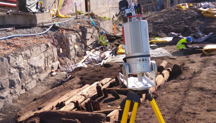 Laserskanner påmontert kamera. Skanneren flyttes rundt konstruksjonen slik at hele bygningen blir dokumentert. Under vårt feltarbeid ble denne bygningskonstruksjonen skannet fra 17 forskjellige posisjoner. De hvite merkene på bakken rundt bygningskonstruksjonen er målepunkter brukt i forbindelse med skanning og fotogrammetri. (Foto: Erich Nau / NIKU) Laserskanner påmontert kamera. Skanneren flyttes rundt konstruksjonen slik at hele bygningen blir dokumentert. Under vårt feltarbeid ble denne bygningskonstruksjonen skannet fra 17 forskjellige posisjoner. De hvite merkene på bakken rundt bygningskonstruksjonen er målepunkter brukt i forbindelse med skanning og fotogrammetri. (Foto: Erich Nau / NIKU)