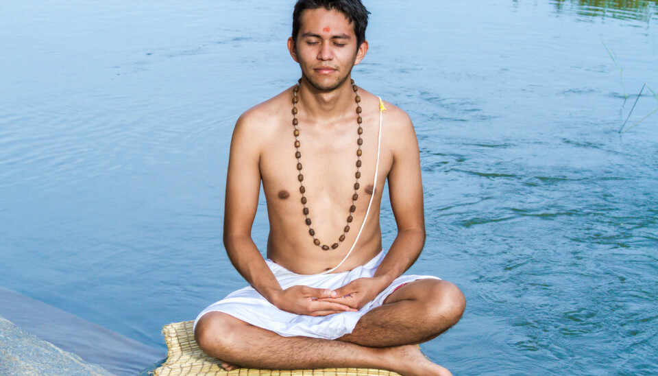 En ung brahmin (prestekasten) mediterer ved elvebredden.  (Foto: Nila Newsom / Shutterstock / NTB scanpix)