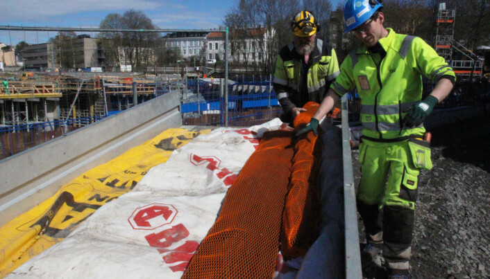 Arkeolog Jani Causevic overser fraktingen av stokkene til et midlertidig vannbad. (Foto: Kristine Ødeby/NIKU) Arkeolog Jani Causevic overser fraktingen av stokkene til et midlertidig vannbad. (Foto: Kristine Ødeby/NIKU)