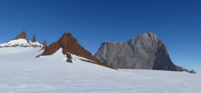 Fargeforskjellen i det lyse fjellet Hoggestabben og de brune pinaklene i Vedkosten reflekterer forskjellen mellom intrusjonsbergartene monzonitt og charnokitt (foto: Ane K. Engvik).