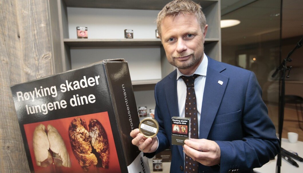Helseminister Bent Høie viser fram de nye røykpakkene og snusboksene som kommer i butikken fra 1. juli i år. Han håper at det standardiserte utseendet på pakkene skal hindre at unge begynner å røyke eller snuse. (Foto: Lise Åserud/NTB scanpix) Helseminister Bent Høie viser fram de nye røykpakkene og snusboksene som kommer i butikken fra 1. juli i år. Han håper at det standardiserte utseendet på pakkene skal hindre at unge begynner å røyke eller snuse. (Foto: Lise Åserud/NTB scanpix)