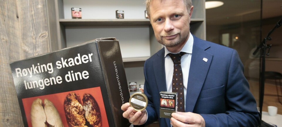 Helseminister Bent Høie viser fram de nye røykpakkene og snusboksene som kommer i butikken fra 1. juli i år. Han håper at det standardiserte utseendet på pakkene skal hindre at unge begynner å røyke eller snuse. (Foto: Lise Åserud/NTB scanpix)