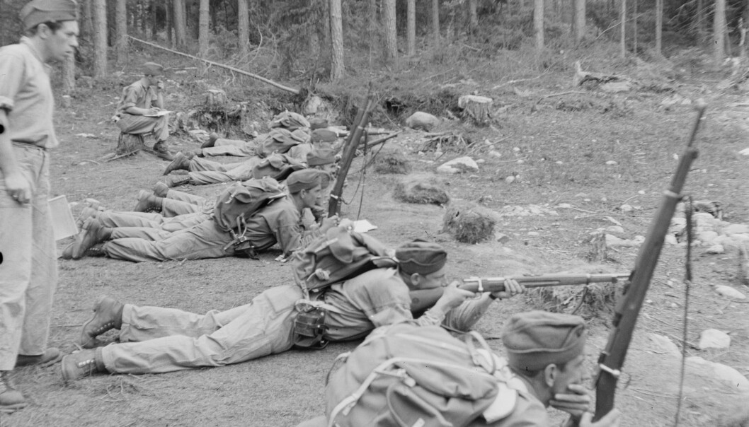 Norske politisoldater driver skyteøvelser i Färnabruk i Vestmanland juli 1944.
Først tillot ikke svenskene noen aktiv norsk utnyttelse av svensk territorium i kampen mot tyskerne. Men fra 1943 ble det bygd opp en norsk militær styrke på svensk jord som skulle bidra under befrielsen av Norge fra tyskerne. Den fikk navnet «polititroppene» og talte på slutten av krigen 14 000 mann. Alle norske mannlige flyktninger til Sverige i vernepliktig alder ble sendt direkte til en av de 16 norske militærforlegningene som ble opprettet. (Foto fra NTBs krigsarkiv) Norske politisoldater driver skyteøvelser i Färnabruk i Vestmanland juli 1944.
Først tillot ikke svenskene noen aktiv norsk utnyttelse av svensk territorium i kampen mot tyskerne. Men fra 1943 ble det bygd opp en norsk militær styrke på svensk jord som skulle bidra under befrielsen av Norge fra tyskerne. Den fikk navnet «polititroppene» og talte på slutten av krigen 14 000 mann. Alle norske mannlige flyktninger til Sverige i vernepliktig alder ble sendt direkte til en av de 16 norske militærforlegningene som ble opprettet. (Foto fra NTBs krigsarkiv)