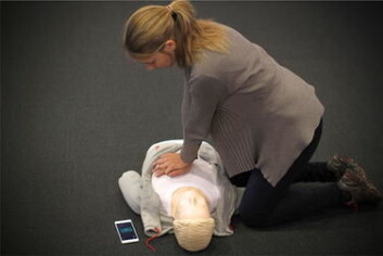 En tilfeldig hjelper som skal utføre hjerte- og lungeredning, kan plassere telefonene ved siden av pasienten. (Foto: (Bildet er gjengitt fra artikkel «Chest compression rate measurement from smartphone video» med tillatelse fra forfatterne.)) En tilfeldig hjelper som skal utføre hjerte- og lungeredning, kan plassere telefonene ved siden av pasienten. (Foto: (Bildet er gjengitt fra artikkel «Chest compression rate measurement from smartphone video» med tillatelse fra forfatterne.))