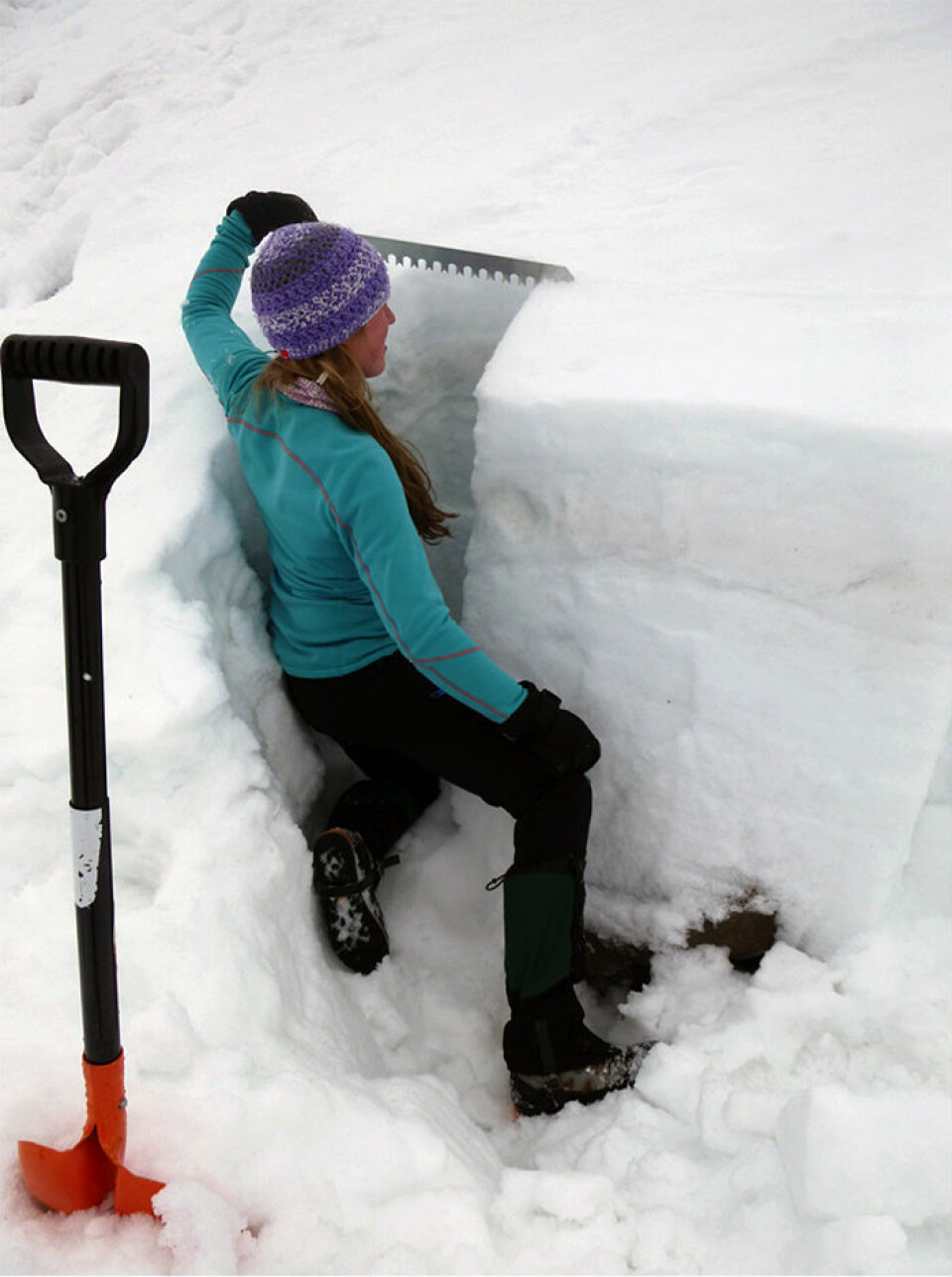 En student fra UNIS undersøker en snøgrop for å finne svake lag. (Foto: Alexander Prokop)
