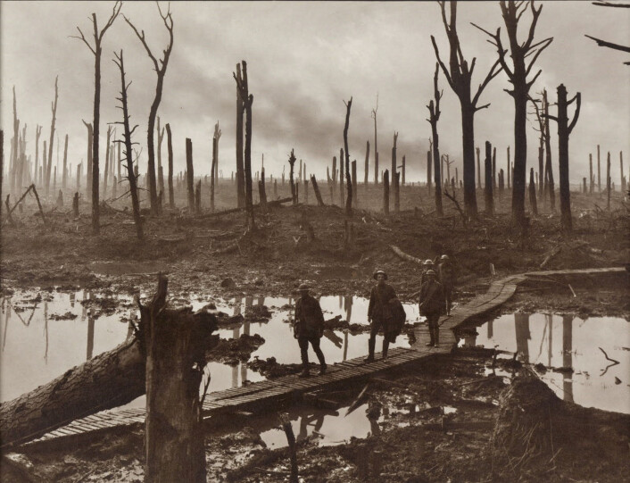 Fem soldater foran det vanvittig ødelagte landskapet i nærheten av Ypres under slaget ved Passchendaele. (Foto: Frank Hurley) Fem soldater foran det vanvittig ødelagte landskapet i nærheten av Ypres under slaget ved Passchendaele. (Foto: Frank Hurley)