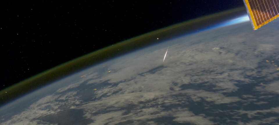 Natthimmellys vises som en tynn stripe over jordskorpen og midt i bildet en meteor som brenner opp idet den treffer atmosfæren. Bildet er tatt fra den internasjonale romstasjonen (ISS) over Irkutsk, Sibir, 13. august 2011.  (Foto: NASA Earth Observatory)