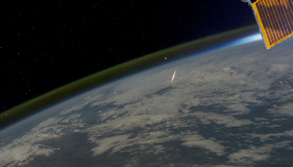 Natthimmellys vises som en tynn stripe over jordskorpen og midt i bildet en meteor som brenner opp idet den treffer atmosfæren. Bildet er tatt fra den internasjonale romstasjonen (ISS) over Irkutsk, Sibir, 13. august 2011.  (Foto: NASA Earth Observatory)