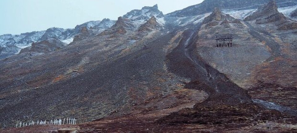 På grunn av regnbyger og et islag halvannen meter inn i fjellskrenten, skled 5000 kubikkmeter slam og mudder rett forbi kirkegården i Longyearbyen på under ett minutt.  (Foto: Ole Humlum)