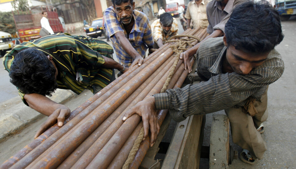 Indiske arbeidere trekker en vogn lastet med stålrør i Mumbai, India. (Foto: REUTERS/Arko Datta (INDIA)/NTB scanpix)