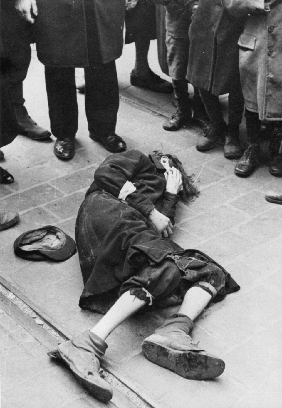 En mann har falt om i gaten, og en folkemengde samler seg rundt ham. Slike sterke scener ble daglig kost for de som ble tvunget til å leve i ghettoen i Warszawa mellom 1941 og 1943. Bildet er fra tidlig i 1941. (Foto: Albert Cusian og Erhard J. Knobloch / NTB scanpix)