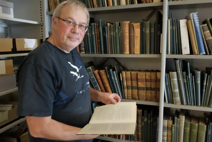 Førsteamanuensis Einar Timdal ved biblioteket til sin forgjenger Bernt Lynge. (Foto: Eivind Torgersen)
