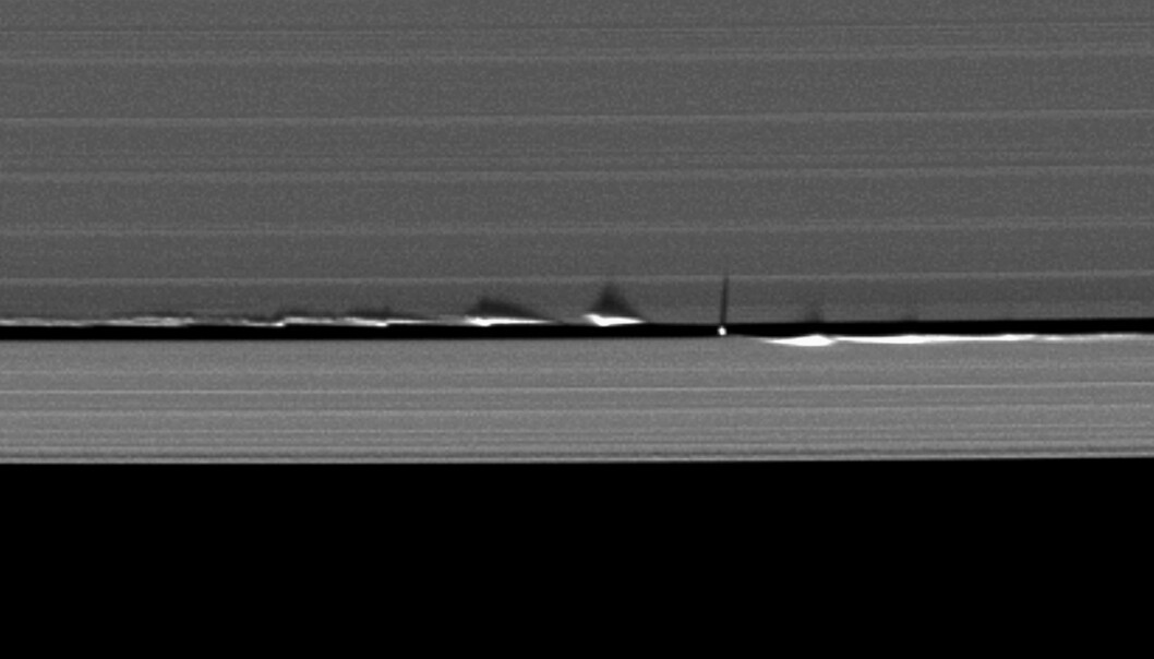 Dette bildet viser hvordan månen Daphnis skaper bølger i Saturns ringer. Daphnis er den lille prikken, mens linjene du ser er ringene. (Bilde: NASA/JPL) Dette bildet viser hvordan månen Daphnis skaper bølger i Saturns ringer. Daphnis er den lille prikken, mens linjene du ser er ringene. (Bilde: NASA/JPL)
