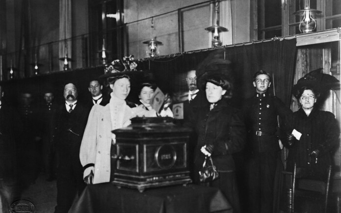 Første kvinne legger stemmeseddelen i urnen ved kommunevalget i Kristiania i 1910. På den tida kunne bare kvinner med en viss inntekt stemme. (Foto: ukjent/Oslo Museum, CC BY-SA 4.0) Første kvinne legger stemmeseddelen i urnen ved kommunevalget i Kristiania i 1910. På den tida kunne bare kvinner med en viss inntekt stemme. (Foto: ukjent/Oslo Museum, CC BY-SA 4.0)
