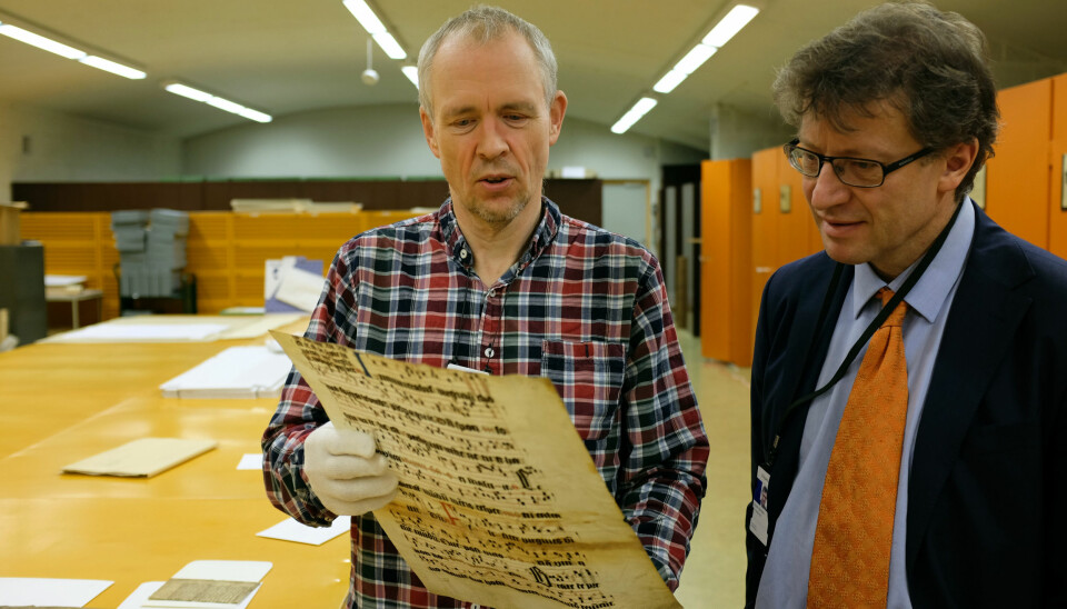 Tor Weidling (t.v.) og Espen Karlsen samarbeider om å finne gamle dokumentfragmenter. Dokumentet her er fra 1300-tallet.  (Foto: Silja Björklund Einarsdóttir/forskning.no)