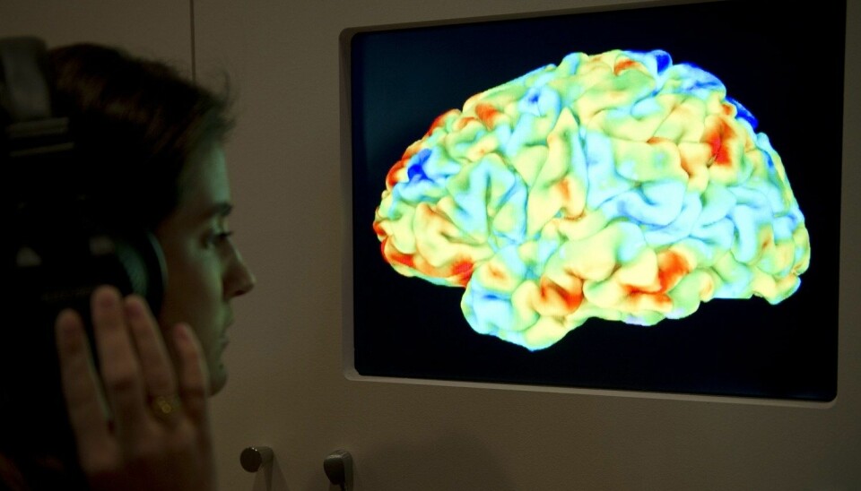 Bildet viser en forsker som ser en hjernescan av en person som hører på klassisk musikk og leser filosofi. Men hvor mye kan slik hjerneforskning egentlig fortelle oss? (Foto: Miguel Medina, AFP, NTB scanpix)
