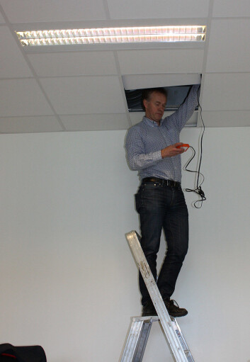 Ikke alt lar seg gjøre via fjernkontroll. Prosjektkoordinator Mads Mysen fra Sintef må stikke hodet opp i taket for å programmere spjeldene som kontrollerer ventilasjonen i klasserommet. (Foto: NILU) Ikke alt lar seg gjøre via fjernkontroll. Prosjektkoordinator Mads Mysen fra Sintef må stikke hodet opp i taket for å programmere spjeldene som kontrollerer ventilasjonen i klasserommet. (Foto: NILU)