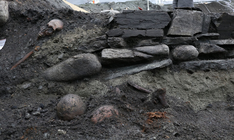 Den nordlige veggen i kirken. Med en grav i profilen, samt en beinsamling i forgrunnen. FOTO: NIKU