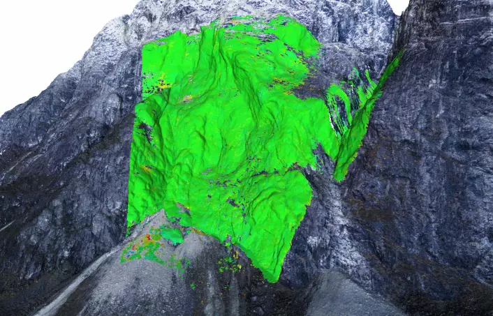 Den grå 3D-modellen er laget ut fra foto tatt fra drone. De fargede feltene viser radarmålinger av bevegelser i berget. Gult og rødt markerer steder der det er opp mot fire millimeter forflytninger (rødt) i løpet av ett år. (Foto: (Bilde: NGI, Creative Commons navngivelse))