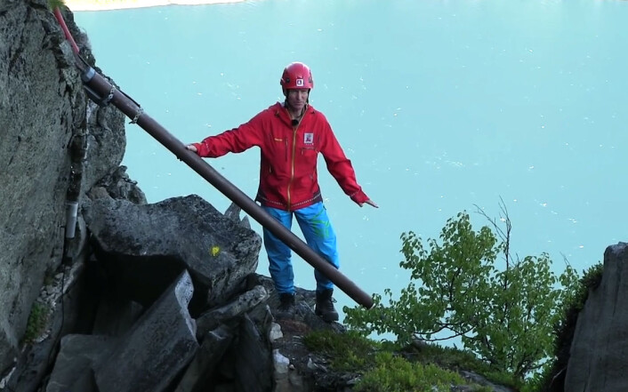 Strekkstag kan måle bevegelser i fjellsprekker. Lars Harald Blikra viser hvordan staget er festet. Til venstre er fst fjell, til høyre er løst fjell som beveger seg ned mot fjorden. Fra en video laget av NVE. Se videoen her! (Foto: NVE) Strekkstag kan måle bevegelser i fjellsprekker. Lars Harald Blikra viser hvordan staget er festet. Til venstre er fst fjell, til høyre er løst fjell som beveger seg ned mot fjorden. Fra en video laget av NVE. Se videoen her! (Foto: NVE)