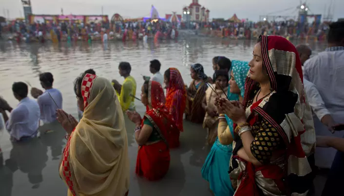 Hinduer utfører et religiøst ritual ved elven Brahmaputra i 2018. (Bilde: AP Photo/Anupam Nath/NTB Scanpix)