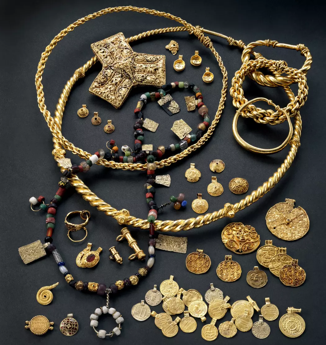 Hoen-skatten som ble funnet i en myr i 1834. Det er 50 smykker, 20 mynter og 200 perler og halvedelstener. De kommer fra det som nå er Midtøsten og hele Europa, men noen av smykkene er produsert i Norge. (Foto: Kulturhistorisk museum, Universitetet i Oslo, lisens CC BY-SA 4.0)