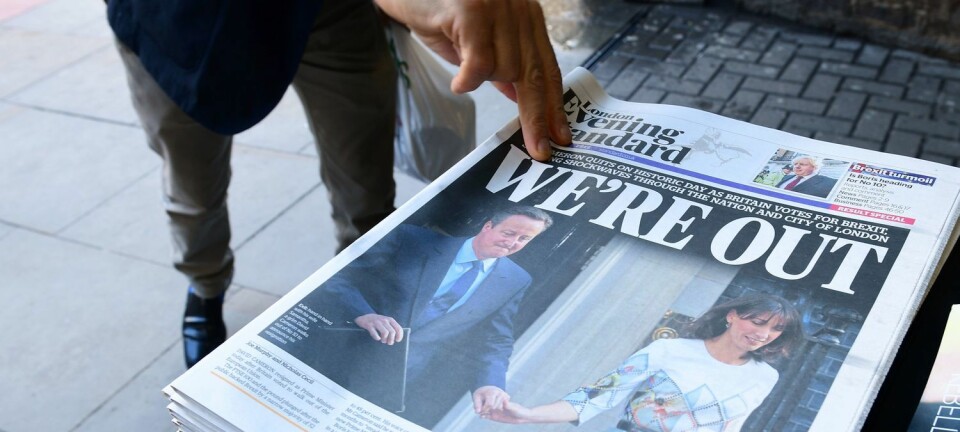 En mann plukker med seg en utgave av London Evening Standard. David Cameron går av etter nederlaget i folkeavstemningen i går, der et flertall stemte for at Storbritannia skal ut av EU. Dette kan føre til at også økonomien går nedover, mener norsk økonomiforsker.  (Foto: AFP/NTB/Scanpix)