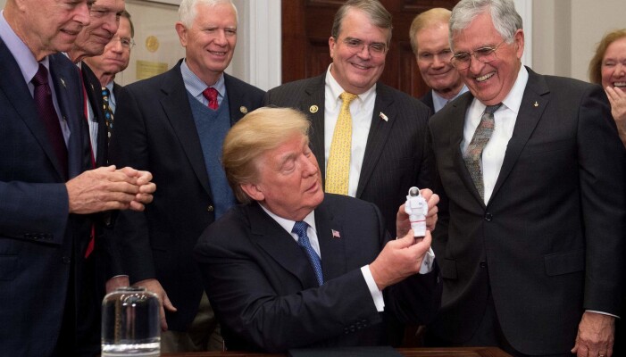 Trump holder en liten astronaut-leke etter å ha undertegnet Space Policy Directive 1 i 2017. (Bilde: AFP PHOTO / SAUL LOEB) Trump holder en liten astronaut-leke etter å ha undertegnet Space Policy Directive 1 i 2017. (Bilde: AFP PHOTO / SAUL LOEB)