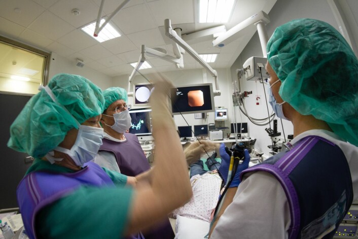 Tolv ulike dataskjermer, tre leger, en ingeniør, en cytodiagnostiker, fire sykepleiere og en pasient må til under forsøket. Undersøkelsen ledes av lungelege Tore Amundsen mens lege Hanne Sorger står ved spakene. (Foto: Thor Nielsen) Tolv ulike dataskjermer, tre leger, en ingeniør, en cytodiagnostiker, fire sykepleiere og en pasient må til under forsøket. Undersøkelsen ledes av lungelege Tore Amundsen mens lege Hanne Sorger står ved spakene. (Foto: Thor Nielsen)