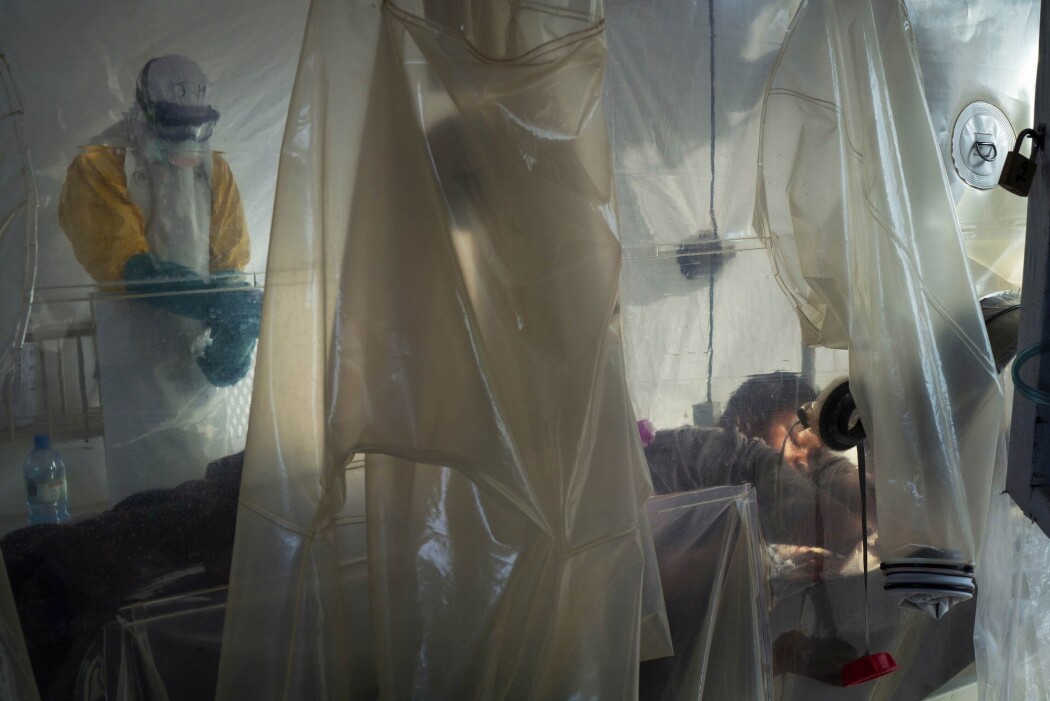 Helsepersonell iført beskyttelsesutstyr undersøker en pasient som ligger i isolat ved et behandlingssenter for ebola i Beni i Kongo. (Foto: AP, NTB scanpix) Helsepersonell iført beskyttelsesutstyr undersøker en pasient som ligger i isolat ved et behandlingssenter for ebola i Beni i Kongo. (Foto: AP, NTB scanpix)