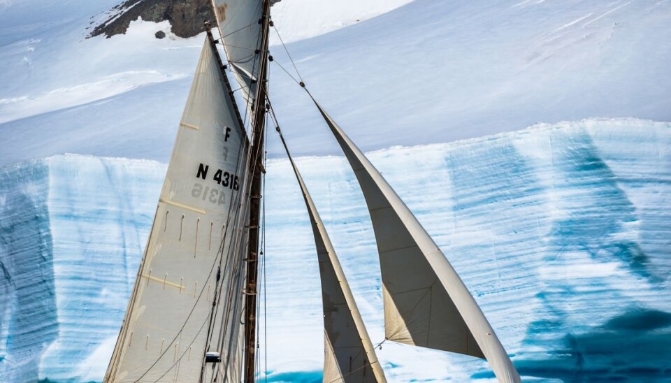 Seilskøyten Lady Free foran et isfjell, som sett fra Halvmåneøyen i Antarktis. (Foto: Magnus Brandseth)