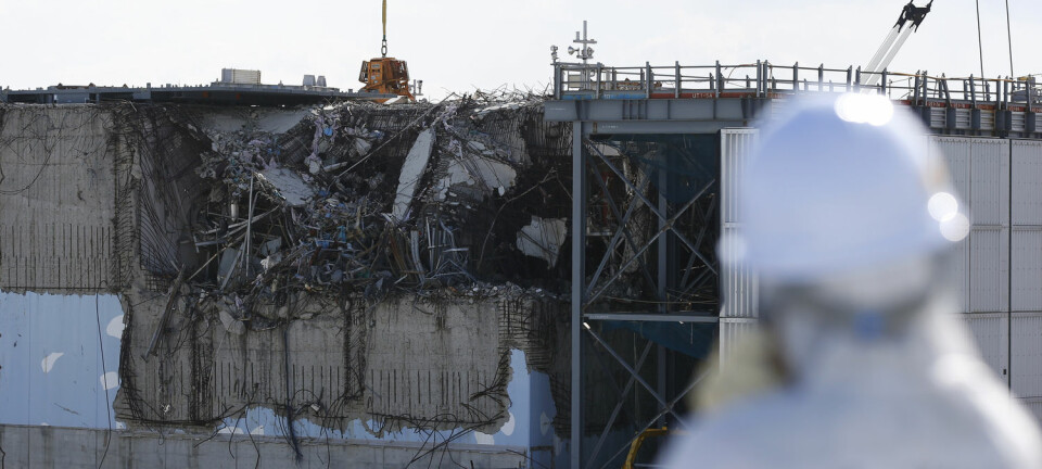 En besøkende journalist ser på en av de skadde reaktorhusene ved Fukushima Daiichi-kraftverket i februar 2016.  (Foto: Toru Hanai/Reuters/NTB Scanpix)