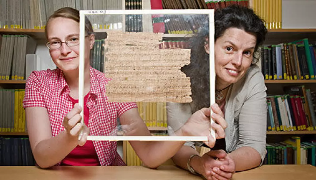 Anastasia Maravela (right), professor of Greek at UiO, heads the team studying the papyruses in the University of Oslo Library. The team also includes Joanne Vera Stolk (left), PhD student, who is here showing us the papyrus fragment that has been found to provide new knowledge on the last poet of antiquity. (Photo: John Hughes)